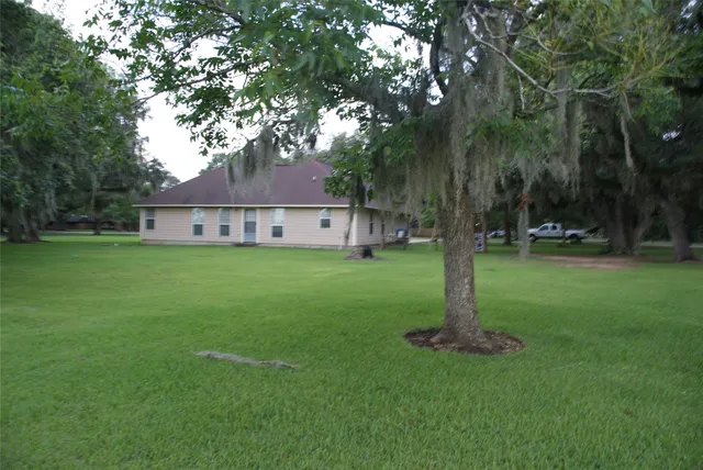 a front view of a house with a yard and tree