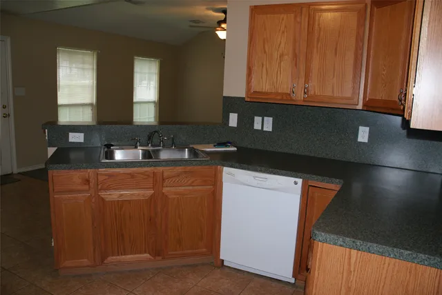 a kitchen with stainless steel appliances granite countertop white cabinets sink and dishwasher