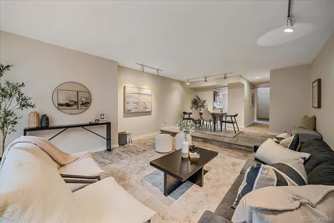 a living room with furniture a clock on wall and a table