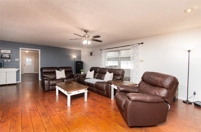 a living room with furniture and a wooden floor