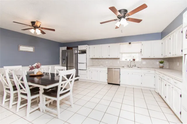a kitchen with stainless steel appliances cabinets a dining table and chairs