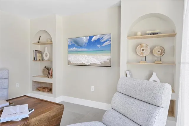 a living room with furniture and a painting on the wall
