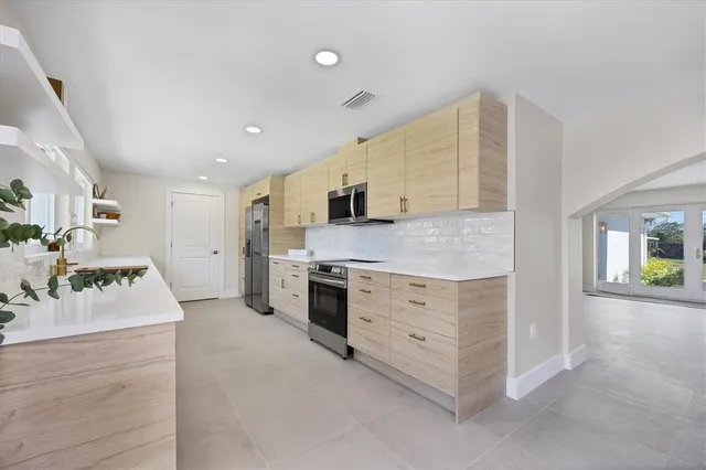 a kitchen with stainless steel appliances kitchen island granite countertop a stove and a sink