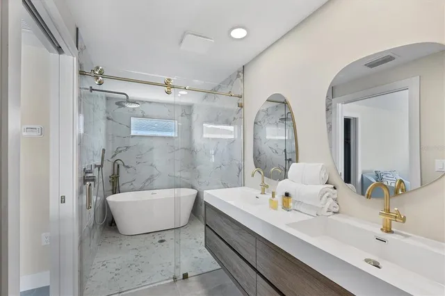 a en suite bathroom with a double vanity sink a mirror and a bathtub