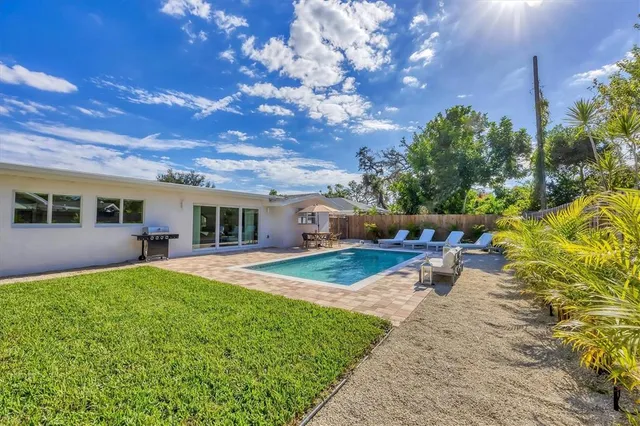 a view of a backyard with couches plants and large tree
