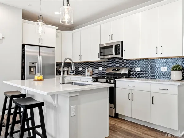 a kitchen with granite countertop white cabinets and stainless steel appliances