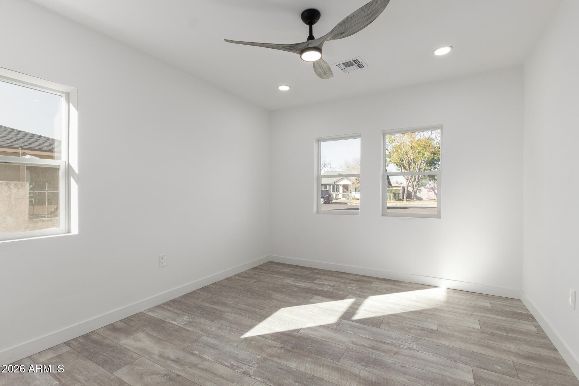 9309 West Adams Street Tolleson, AZ 85353 - Photo 11 of 29 a view of empty room with wooden floor and fan