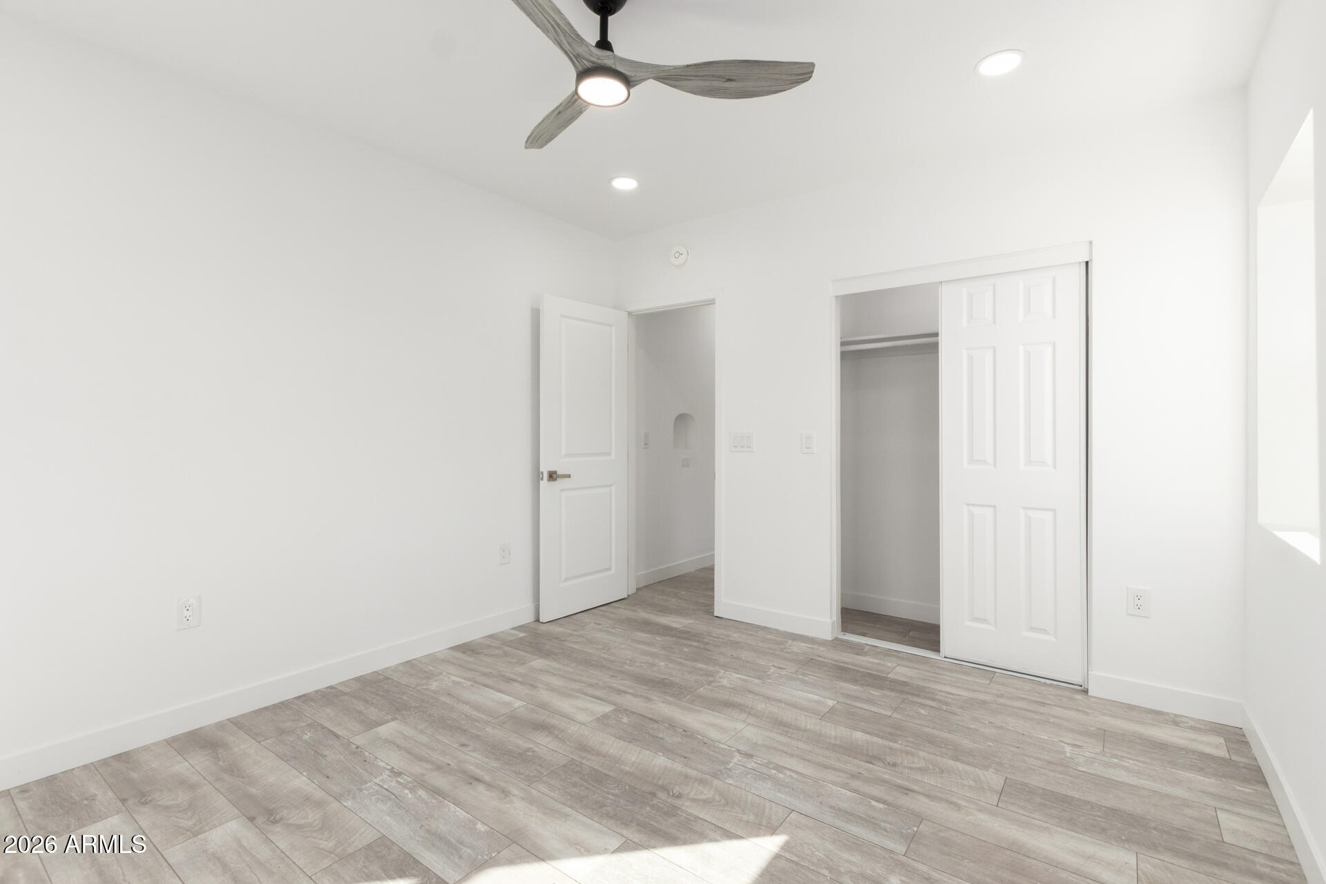 9309 West Adams Street Tolleson, AZ 85353 - Photo 16 of 29 an empty room with a ceiling fan and carpet