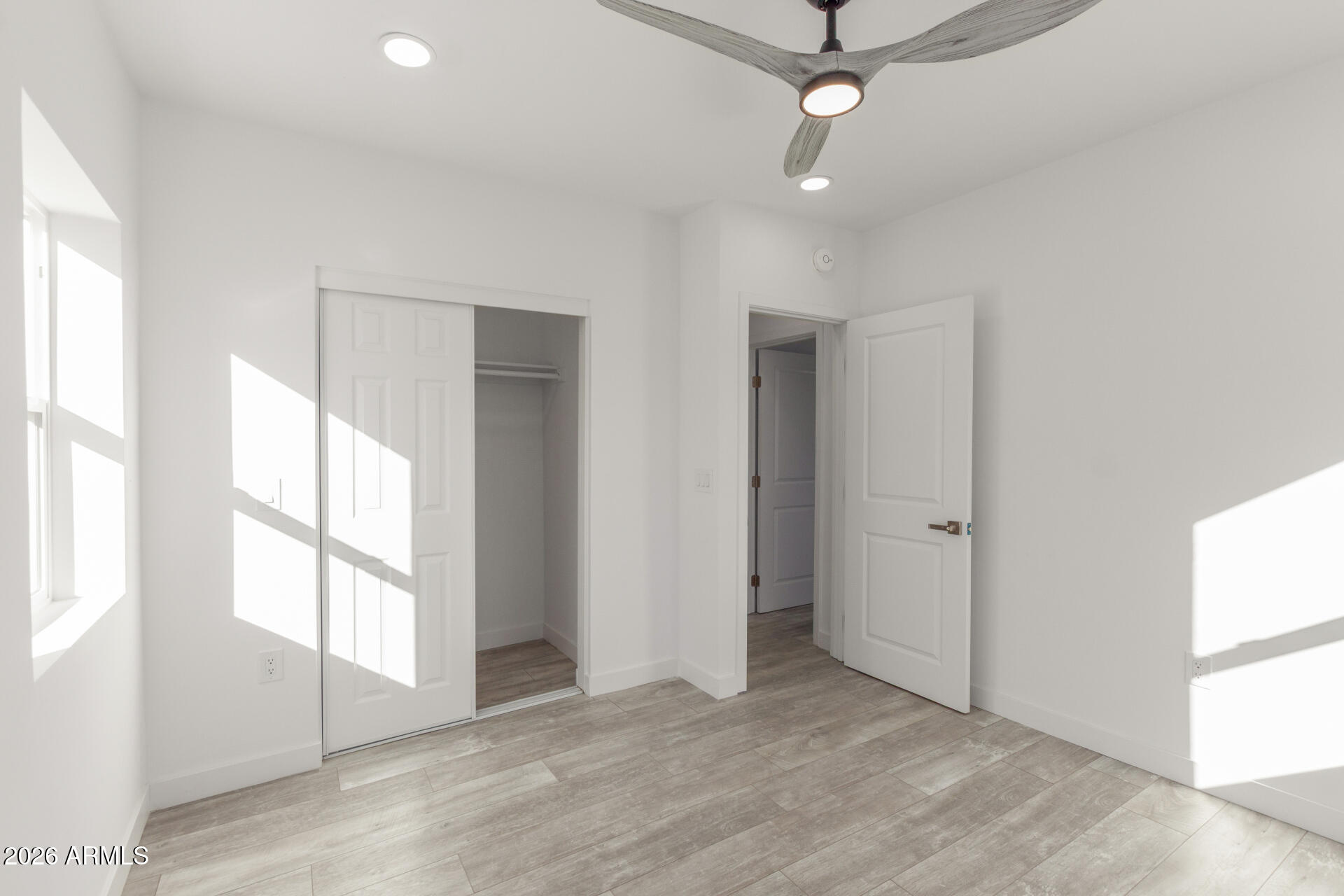 9309 West Adams Street Tolleson, AZ 85353 - Photo 18 of 29 wooden floor in an empty room with a window