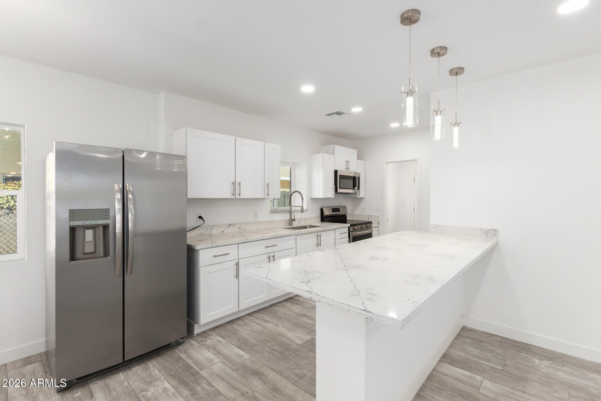 9309 West Adams Street Tolleson, AZ 85353 - Photo 8 of 29 a kitchen with stainless steel appliances a refrigerator sink and microwave