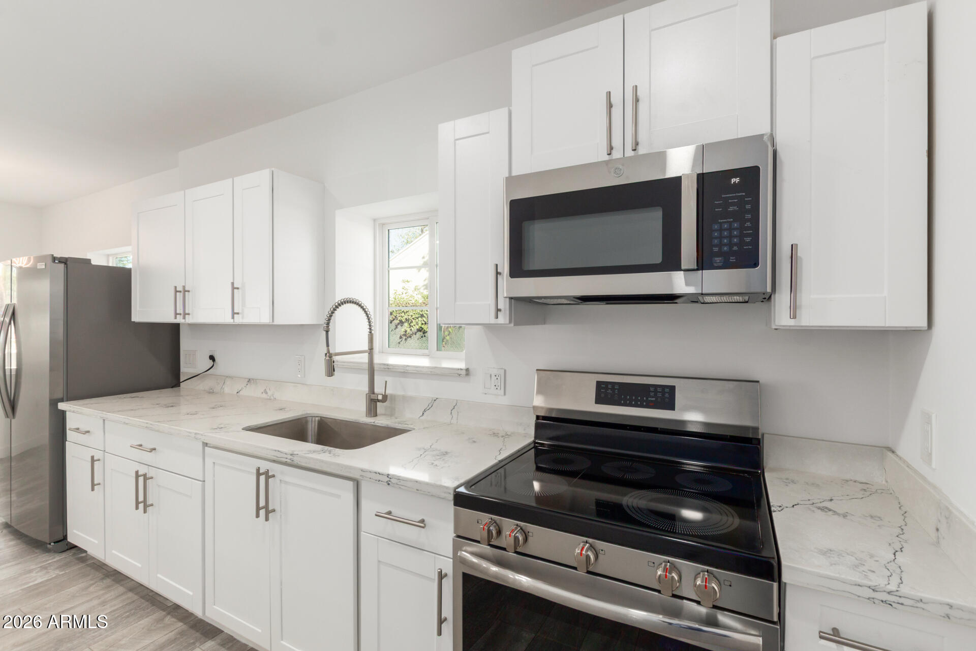 9309 West Adams Street Tolleson, AZ 85353 - Photo 9 of 29 a kitchen with stainless steel appliances granite countertop a stove microwave and sink