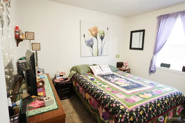 a bedroom with bed and a flat tv screen