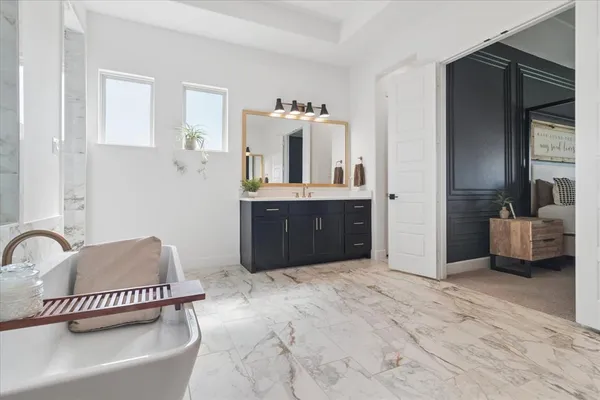 a spacious bathroom with a tub sink and mirror