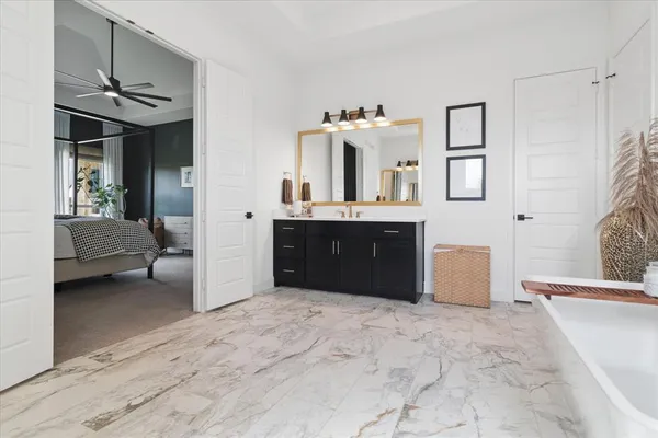 a spacious bathroom with a tub sink and mirror