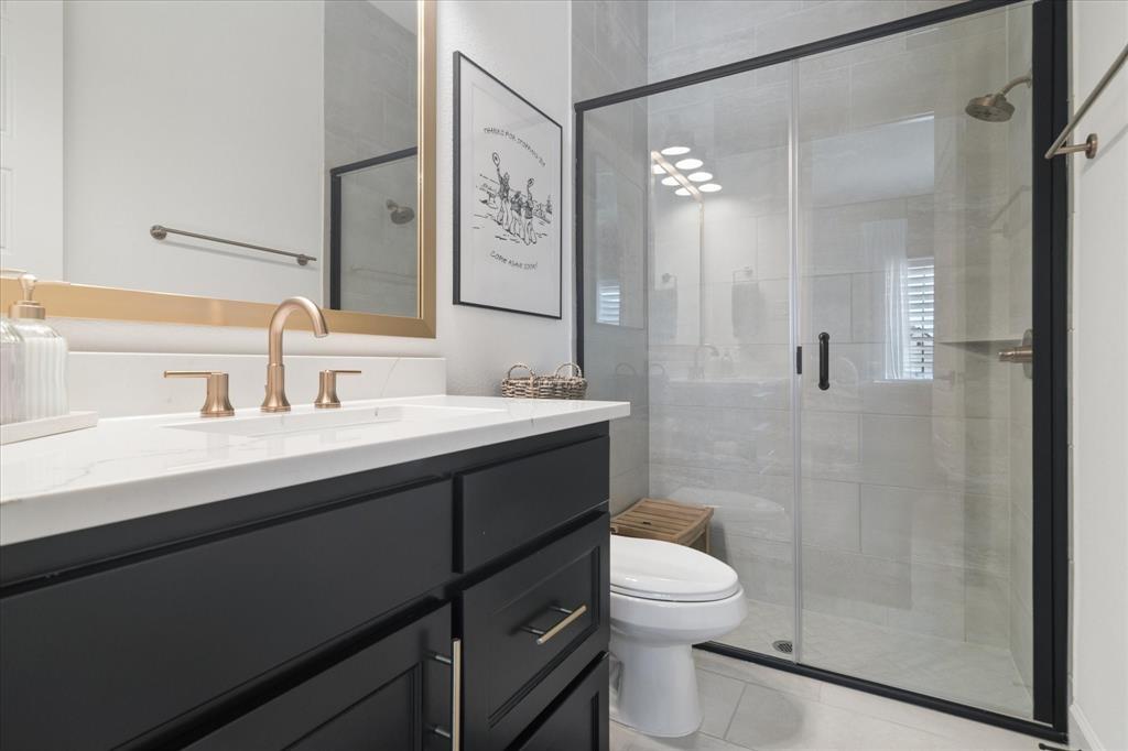 582 Broadleaf Way Haslet, TX 76052 - Photo 24 of 38 a bathroom with a toilet a sink a mirror a shower and vanity