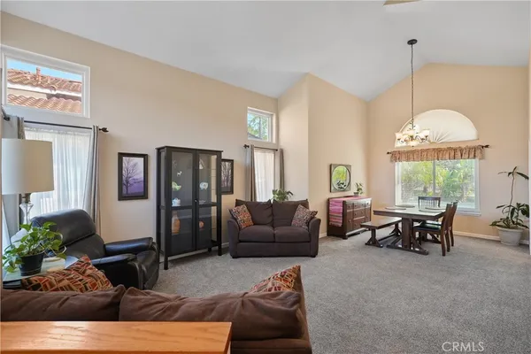 a living room with stainless steel appliances kitchen island granite countertop furniture and a large window