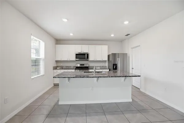 a kitchen with stainless steel appliances a refrigerator sink and microwave