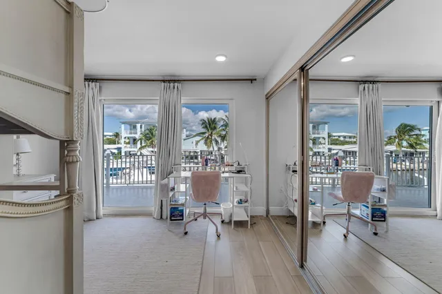 a bedroom with a balcony a bed and painting on the wall