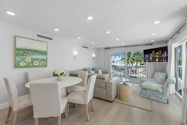 a view of a dining room with furniture a potted plant and wooden floor