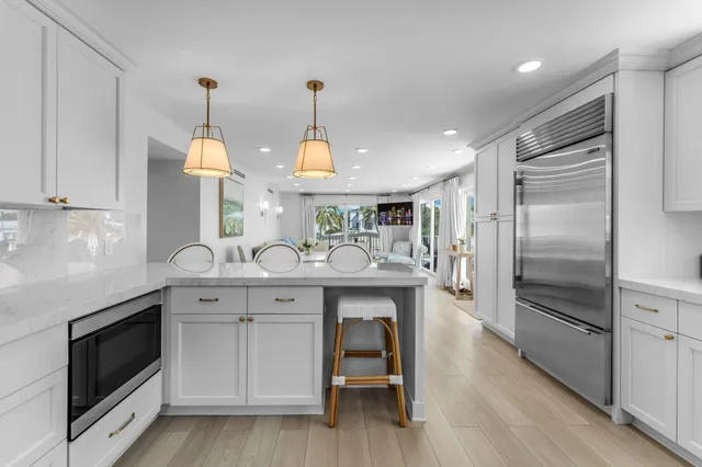 a kitchen with stainless steel appliances granite countertop white cabinets and a stove top oven