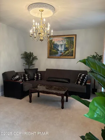 a living room with furniture piano and a chandelier