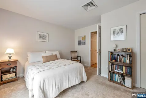 a bedroom with a bed a book shelf and a window