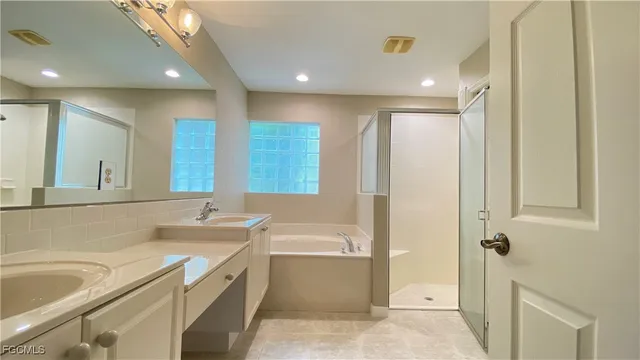 a bathroom with a granite countertop sink mirror and a bathtub