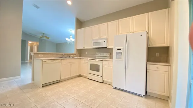 a kitchen with white cabinets and white appliances