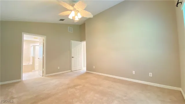 a view of an empty room and chandelier fan