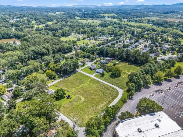 an aerial view of residential houses with outdoor space and trees