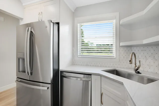 a kitchen with stainless steel appliances granite countertop a refrigerator and a sink
