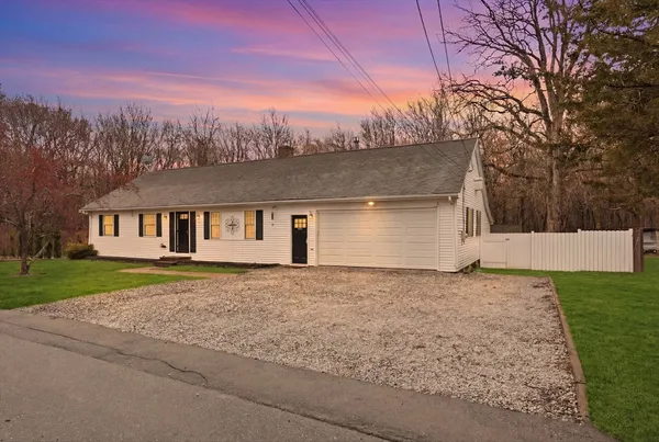 a front view of a house with a yard and trees