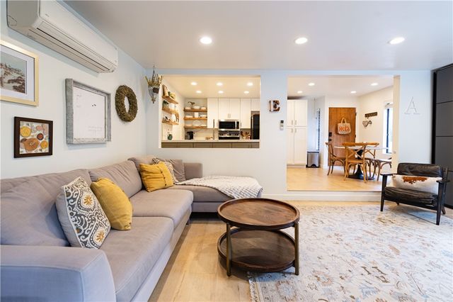 a living room with furniture a rug and a view of kitchen