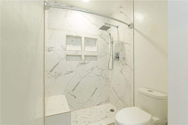 a bathroom with a toilet and a shower