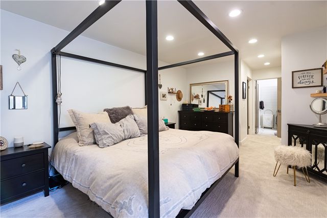 a bedroom with a bed and a dresser with mirror