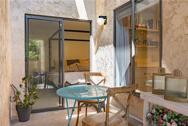 a view of balcony with two chairs and a potted plant