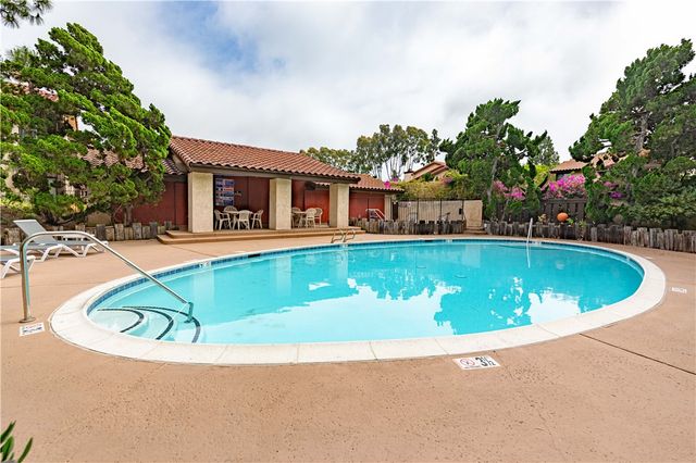 a view of swimming pool with outdoor seating and house in the background