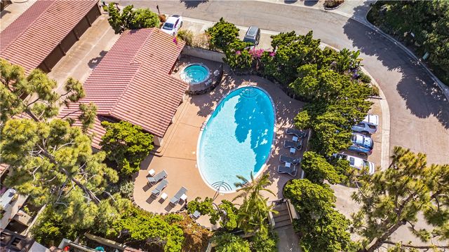an aerial view of a house with a swimming pool and large trees