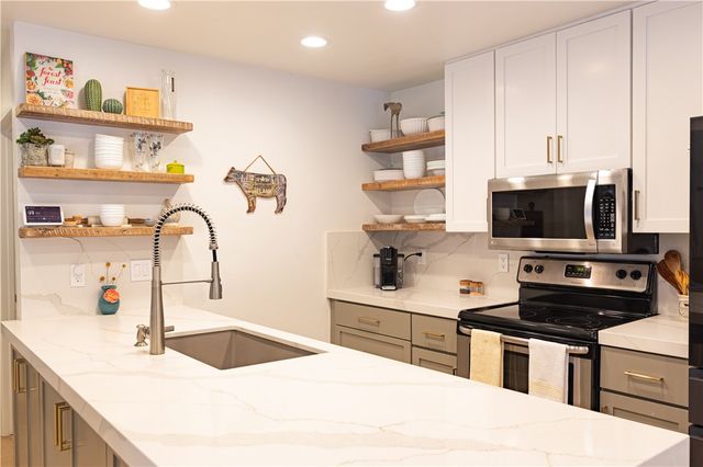 a kitchen with stainless steel appliances a sink a stove and a microwave