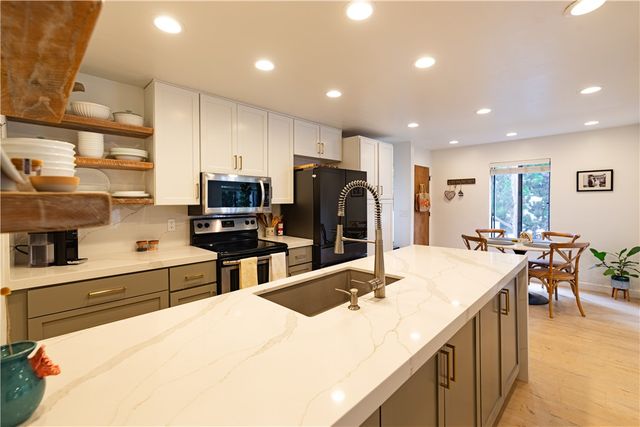 a kitchen with stainless steel appliances kitchen island granite countertop a sink and cabinets
