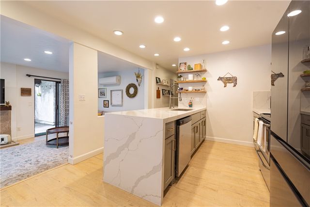 a large kitchen with stainless steel appliances granite countertop a large counter top and a stove
