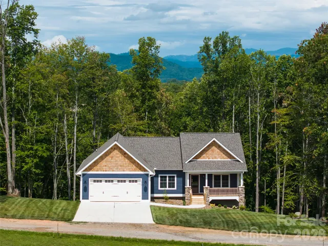 an aerial view of a house with a yard and lake view