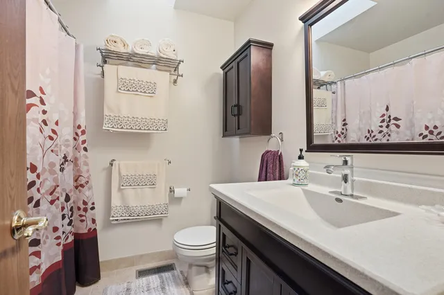 a bathroom with a sink a toilet and a mirror