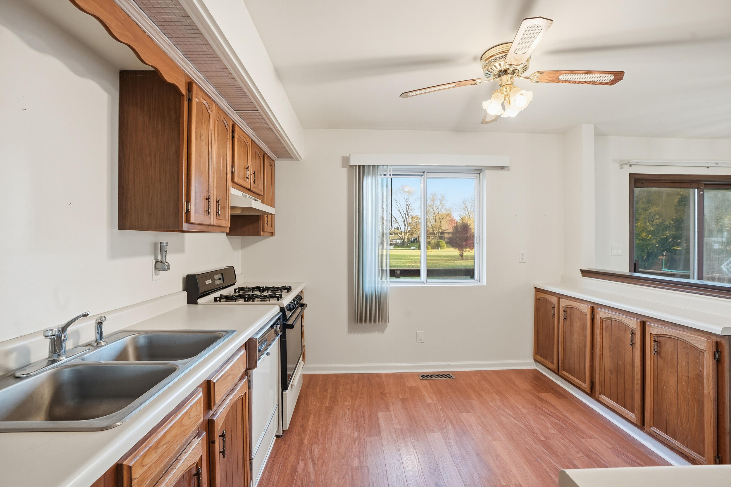 4142 Augusta Drive Crown Point, IN 46307 - Photo 7 of 24 a kitchen with stainless steel appliances granite countertop a sink dishwasher a stove and a refrigerator with wooden floor