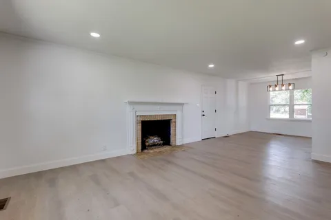 an empty room with windows and fireplace