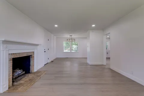 an empty room with windows and fireplace