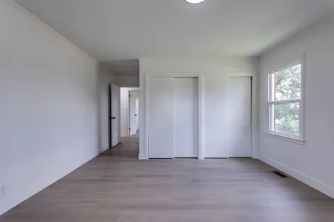 an empty room with windows and closet