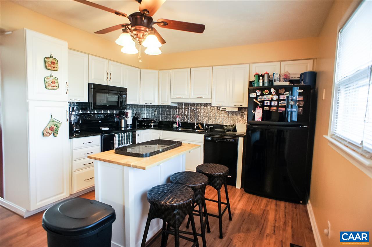 1074 Cedar Grove Road Ruckersville, VA 22968 - Photo 8 of 23 a kitchen with granite countertop a refrigerator a stove a sink a dining table and chairs with wooden floor