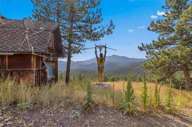 a backyard of a house with table and chairs under an umbrella
