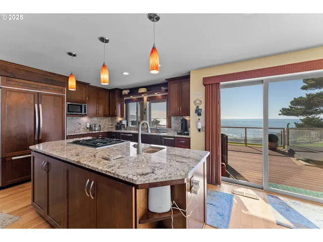 a kitchen with stainless steel appliances granite countertop a sink a stove and a refrigerator